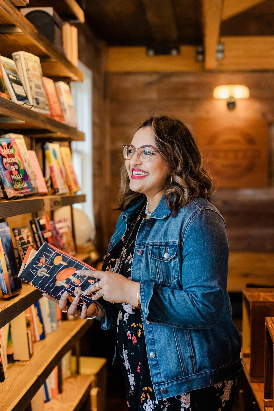 Ashmi browsing a bookstore shelf, holding a novel